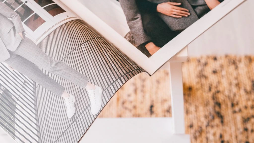 An open printed annual report resting on a desk under a single warm lamp.